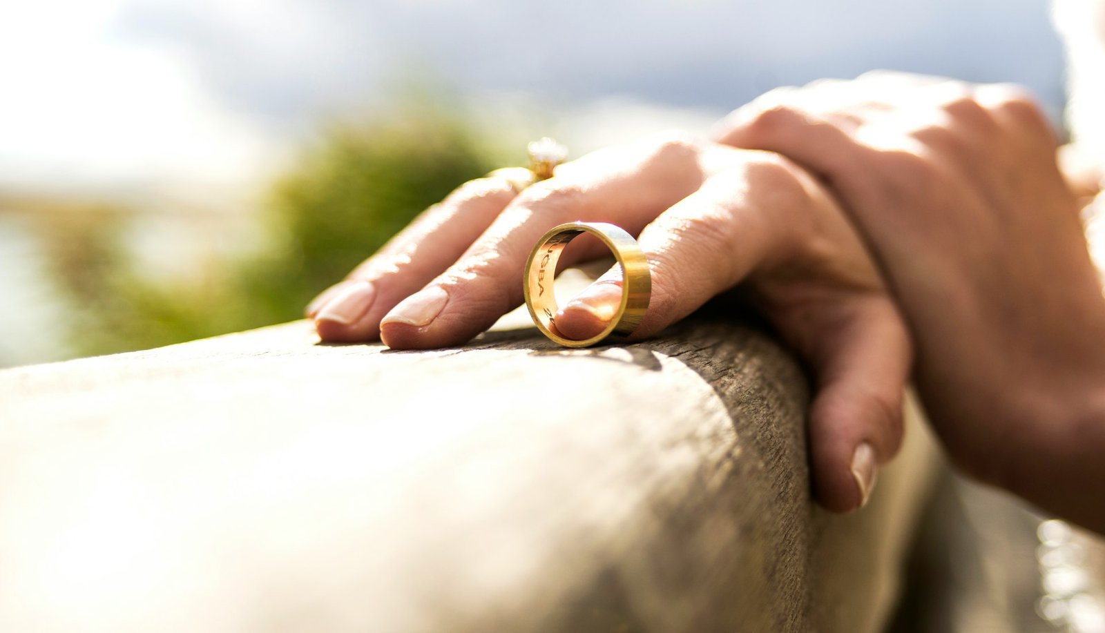 Mão segurando uma aliança de casamento